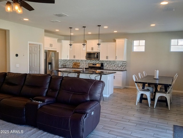 living room featuring ceiling fan and light wood-type flooring