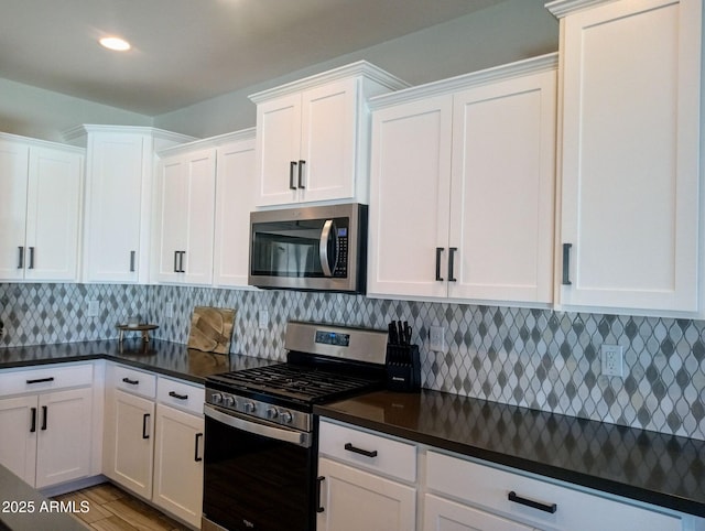 kitchen with white cabinets, stainless steel appliances, light hardwood / wood-style flooring, and decorative backsplash