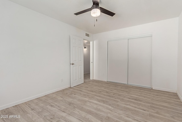 unfurnished bedroom with light hardwood / wood-style floors, a closet, and ceiling fan