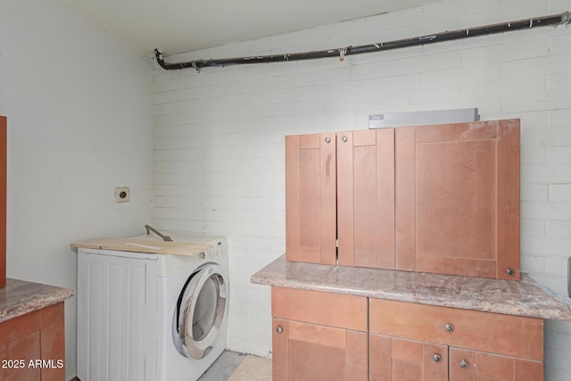 clothes washing area with washer / dryer and cabinets