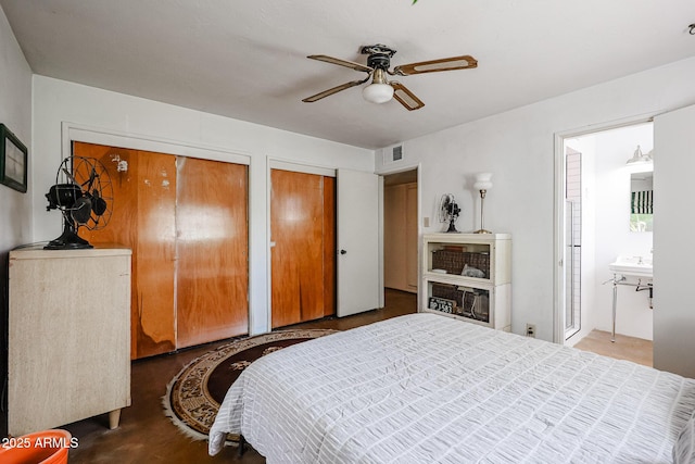bedroom with multiple closets, ceiling fan, and connected bathroom