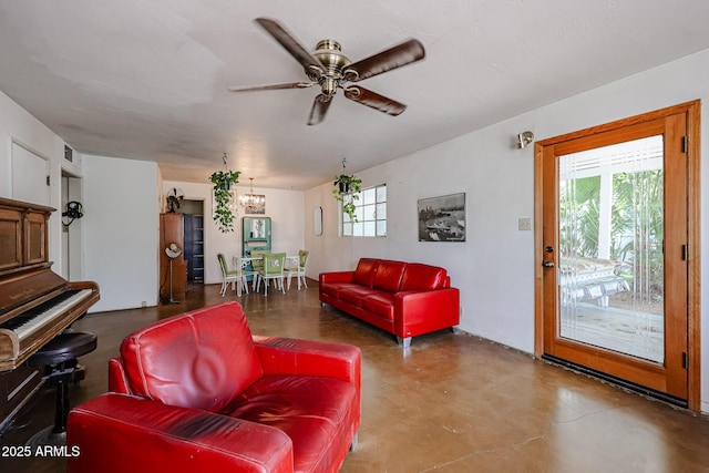 living area featuring a chandelier, finished concrete floors, and ceiling fan