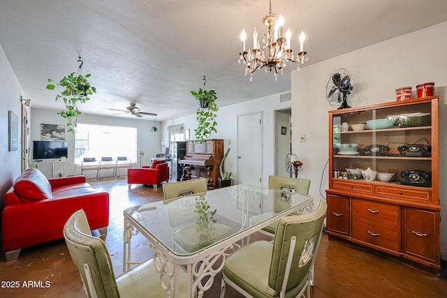 dining room with ceiling fan, a chandelier, and finished concrete flooring