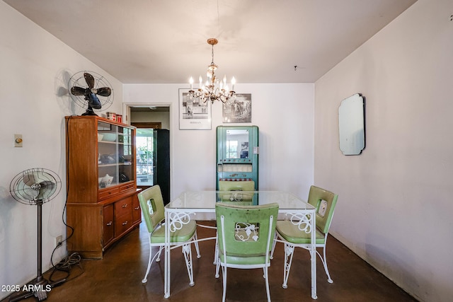 dining room featuring concrete floors and a chandelier