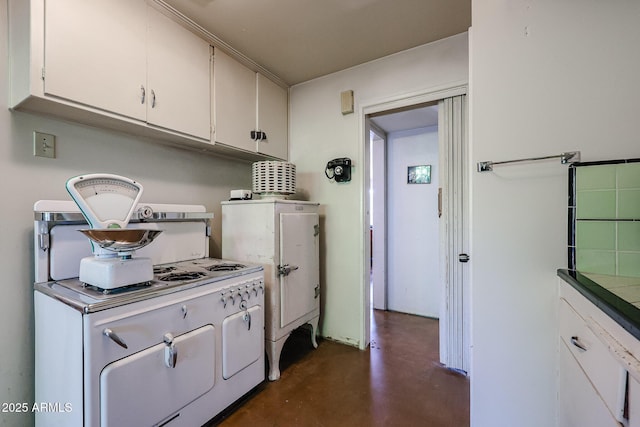 kitchen with concrete floors and white cabinetry