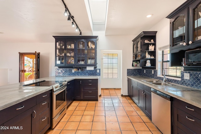 kitchen featuring dark brown cabinetry, sink, stainless steel appliances, backsplash, and light tile patterned floors