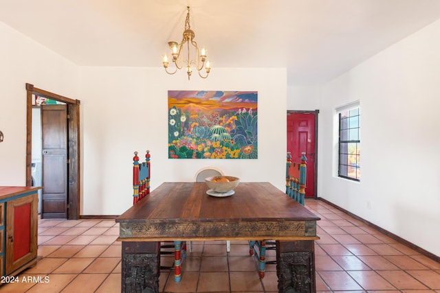 dining space with tile patterned floors and a chandelier