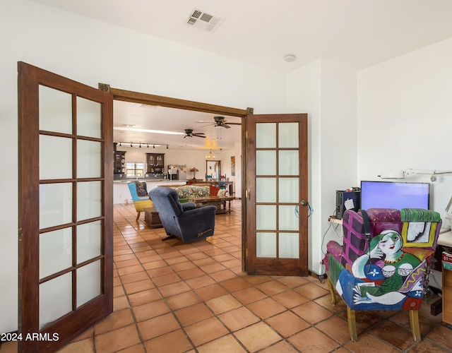 tiled living room featuring ceiling fan and french doors