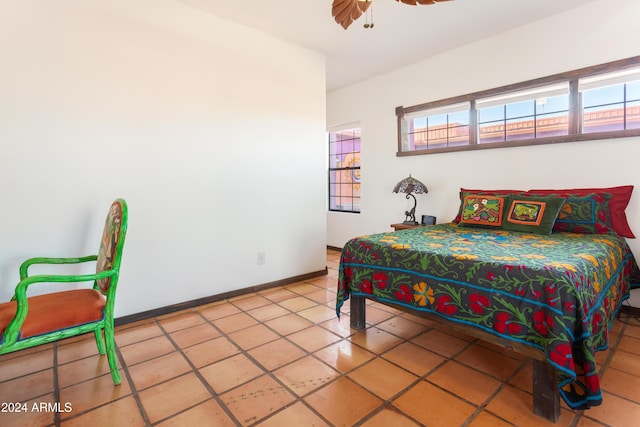 tiled bedroom featuring ceiling fan