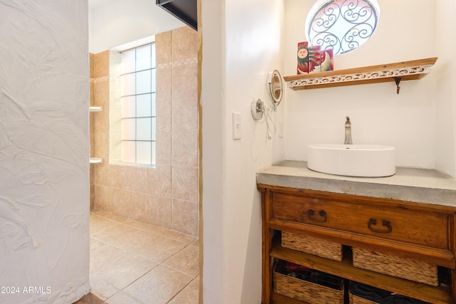 bathroom with plenty of natural light, tiled shower, and vanity