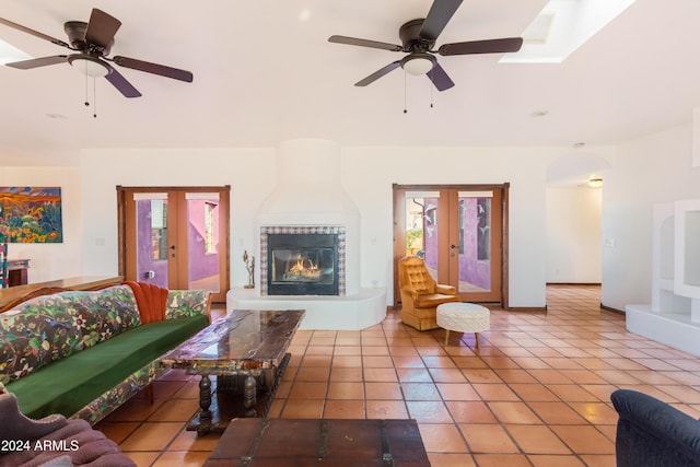 tiled living room with ceiling fan, french doors, and a healthy amount of sunlight