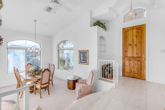 carpeted dining area featuring built in shelves, vaulted ceiling, and ceiling fan with notable chandelier