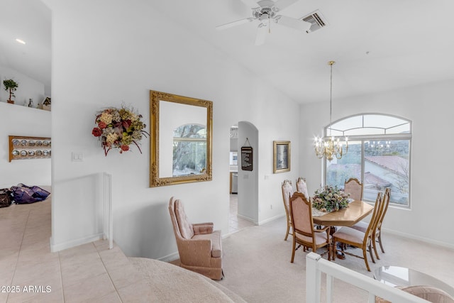 dining area featuring light tile patterned floors, vaulted ceiling, and ceiling fan with notable chandelier