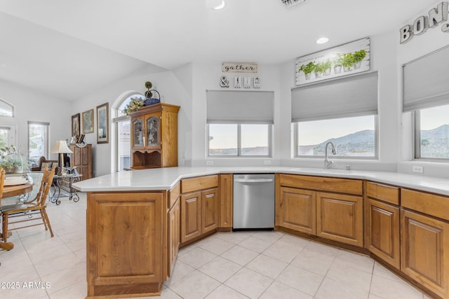 kitchen featuring plenty of natural light, stainless steel dishwasher, kitchen peninsula, and sink