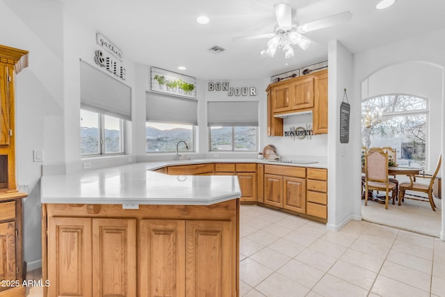 kitchen featuring black electric stovetop, sink, kitchen peninsula, ceiling fan, and light tile patterned floors