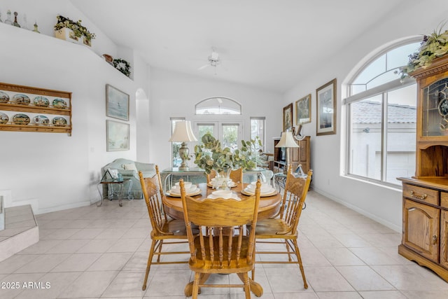 dining room featuring vaulted ceiling, light tile patterned flooring, and french doors