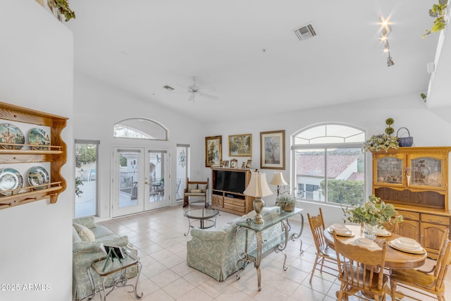 tiled living room featuring ceiling fan and french doors