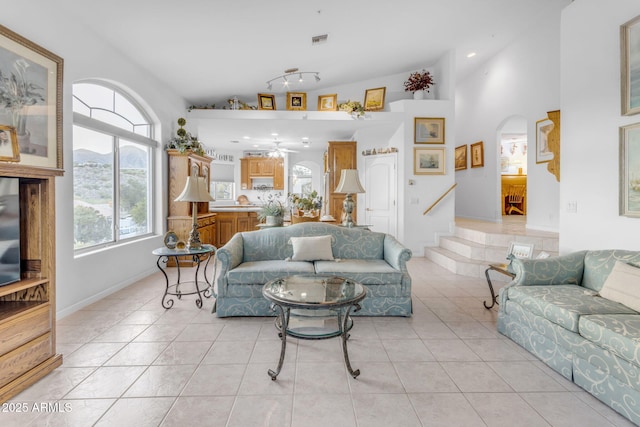 tiled living room featuring ceiling fan and lofted ceiling