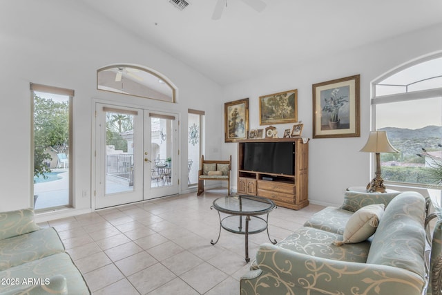 living room featuring ceiling fan, french doors, vaulted ceiling, and light tile patterned flooring