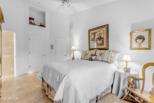 bedroom with ceiling fan and a towering ceiling