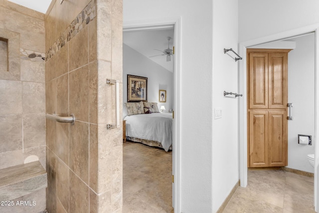 bathroom with toilet, ceiling fan, a tile shower, and lofted ceiling