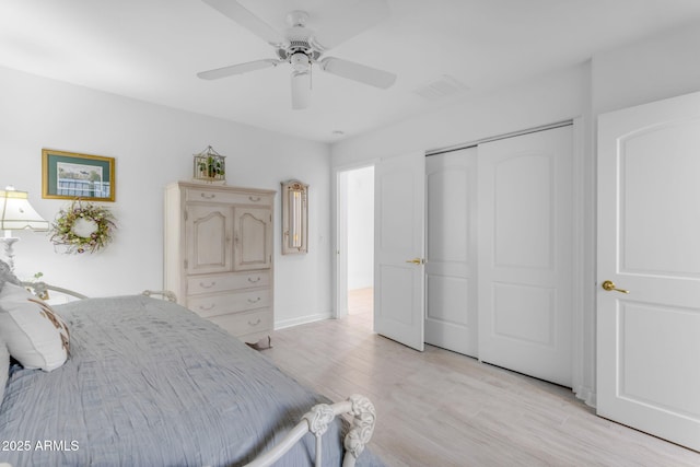 bedroom with ceiling fan, a closet, and light hardwood / wood-style flooring