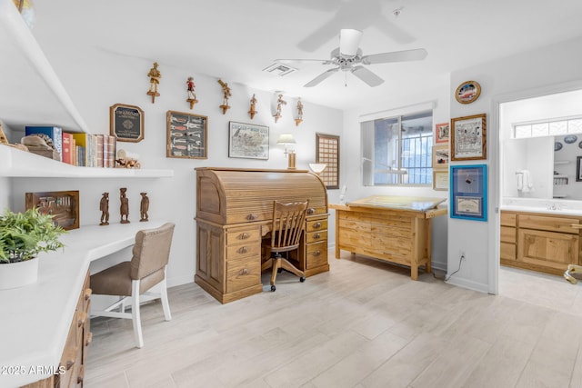 office with ceiling fan, built in desk, and light hardwood / wood-style floors