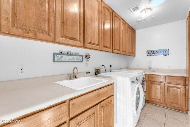 washroom featuring cabinets, light tile patterned floors, washing machine and clothes dryer, and sink