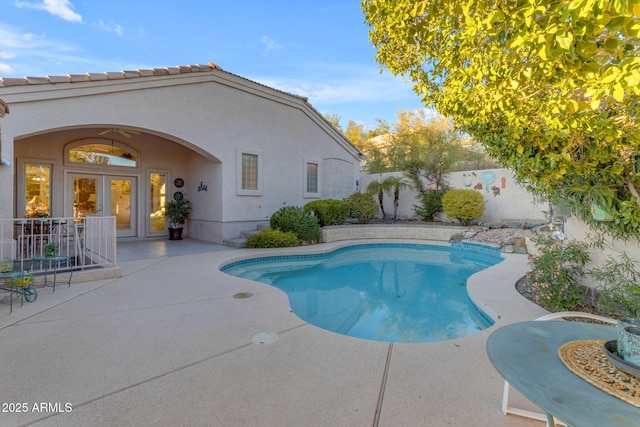 view of swimming pool with french doors and a patio