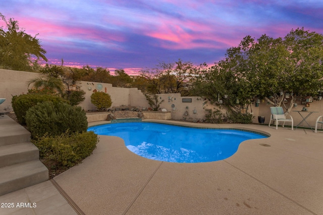 pool at dusk featuring a patio