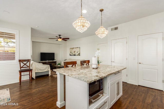 kitchen with white cabinets, decorative light fixtures, dark hardwood / wood-style flooring, and black microwave