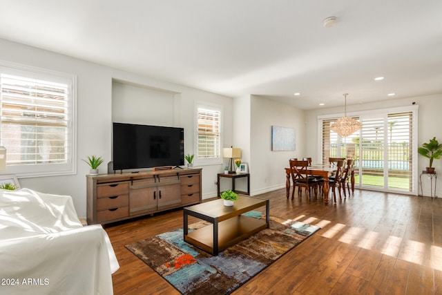 living room with hardwood / wood-style flooring, an inviting chandelier, and plenty of natural light