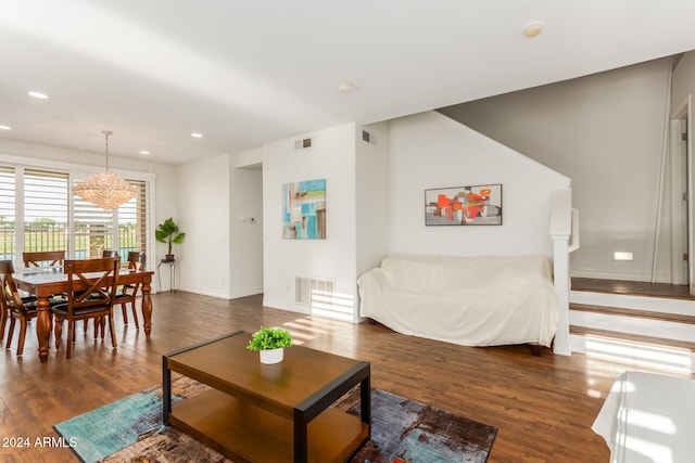 living room with dark hardwood / wood-style floors and an inviting chandelier