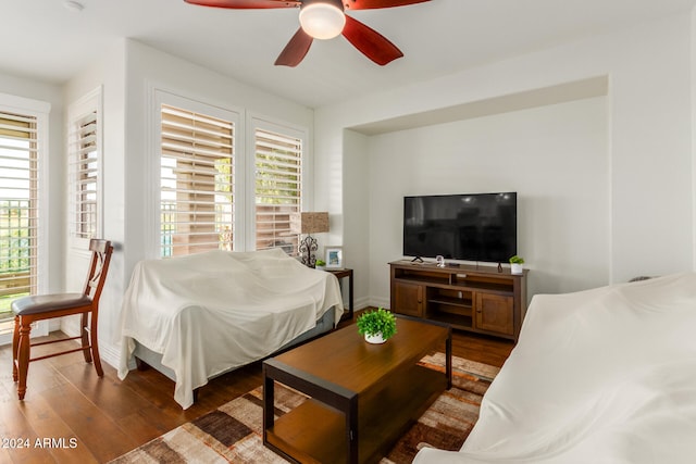 living room featuring ceiling fan and dark wood-type flooring