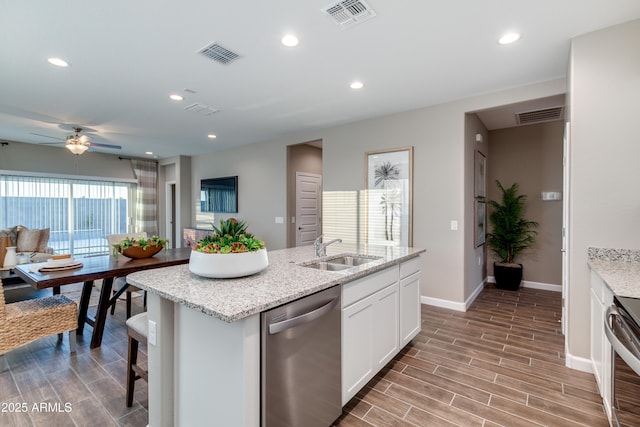 10619 W Bloch Rd, Tolleson, AZ 85353 - kitchen featuring appliances with stainless steel finishes, a ceiling fan, white cabinets, light wood-type flooring, and a center island with sink