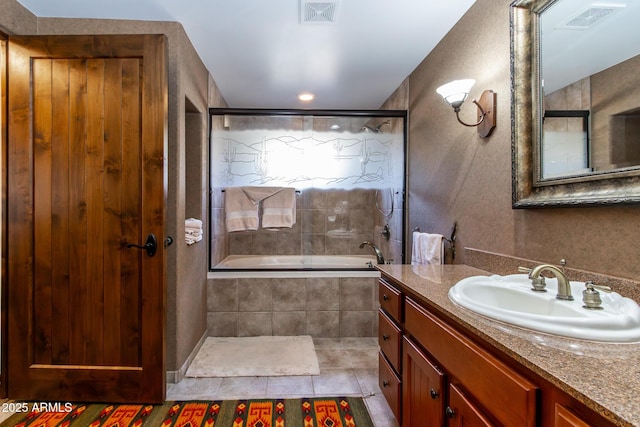 bathroom featuring tile patterned floors, tiled shower / bath combo, and vanity