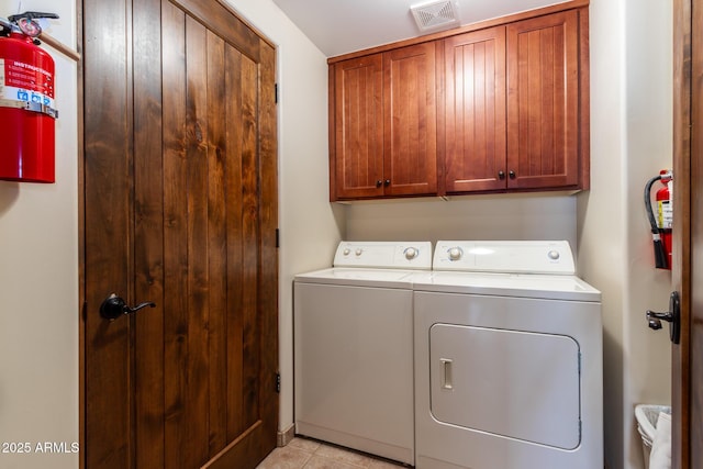 laundry area featuring washing machine and dryer and cabinets