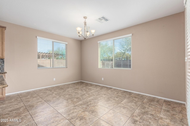 spare room with light tile patterned floors and a notable chandelier