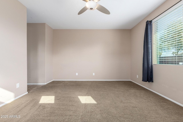 carpeted spare room featuring ceiling fan