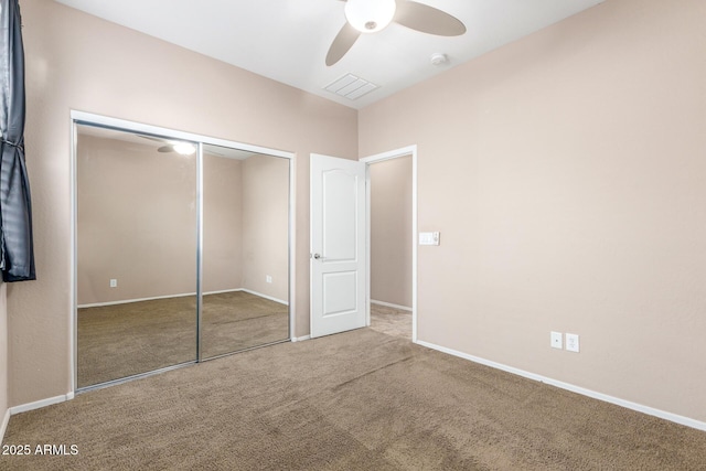 unfurnished bedroom featuring carpet floors, ceiling fan, and a closet