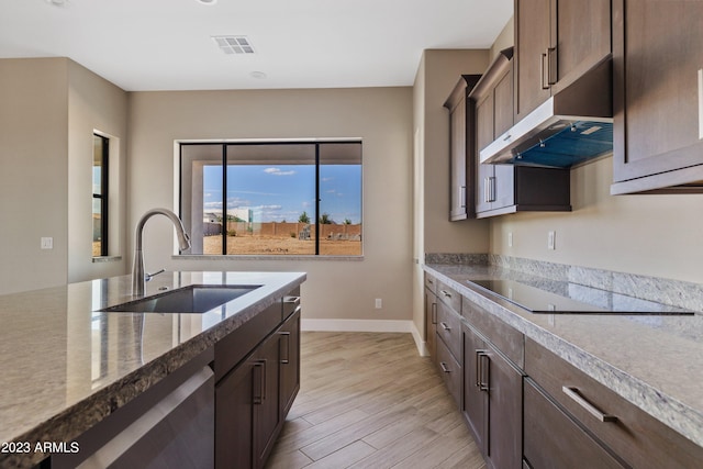 kitchen featuring light hardwood / wood-style floors, sink, black electric stovetop, exhaust hood, and stainless steel dishwasher