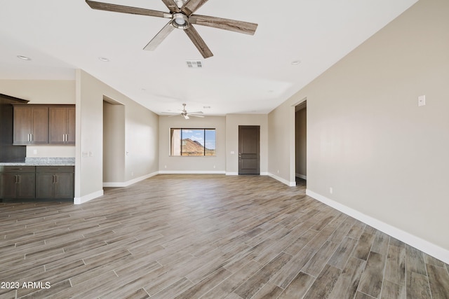 unfurnished living room with ceiling fan and light wood-type flooring