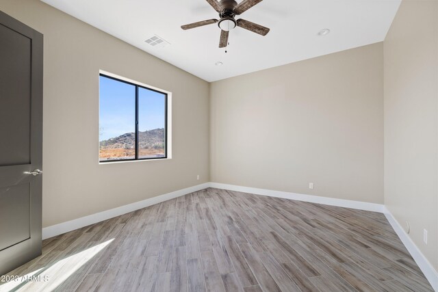 spare room with light hardwood / wood-style flooring and ceiling fan