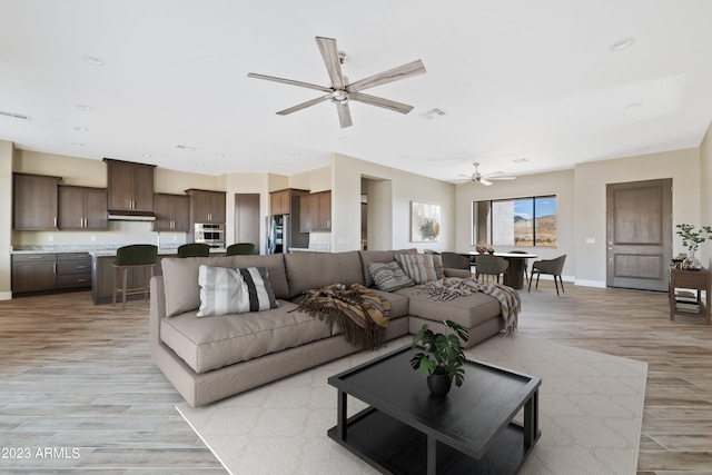 living room featuring ceiling fan and light hardwood / wood-style floors