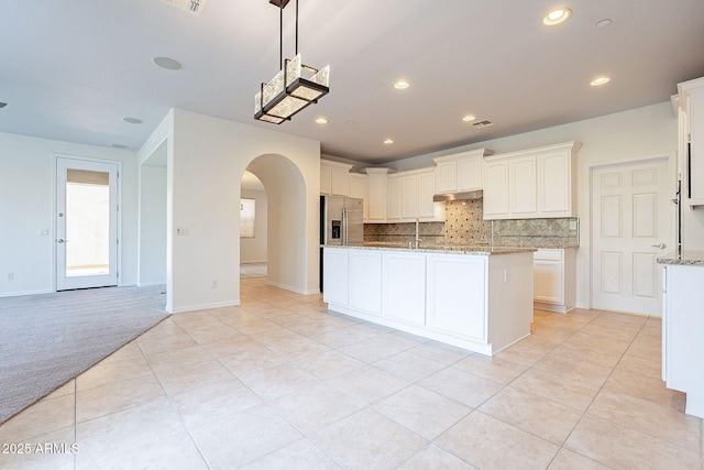 kitchen featuring light stone countertops, sink, light carpet, and white cabinets