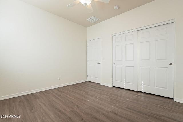 unfurnished bedroom featuring a closet, dark hardwood / wood-style floors, and ceiling fan