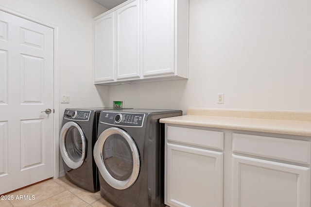 washroom with cabinets, light tile patterned flooring, and washing machine and clothes dryer