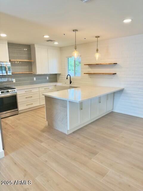 kitchen with open shelves, light countertops, appliances with stainless steel finishes, white cabinetry, and tasteful backsplash