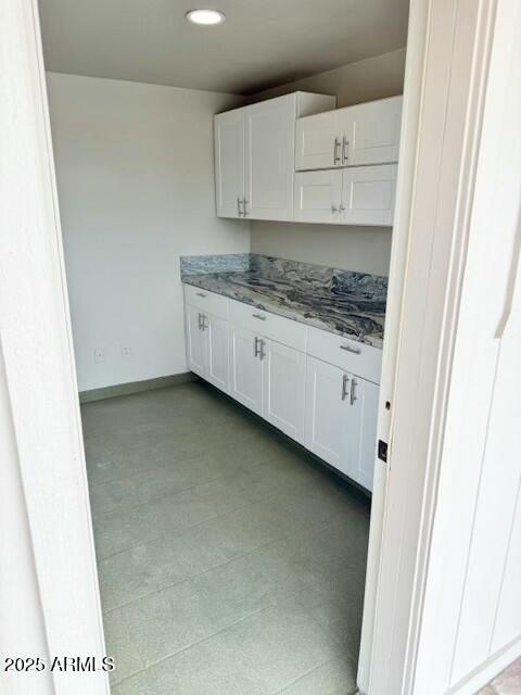 interior space featuring recessed lighting, white cabinets, baseboards, and light stone countertops