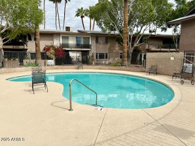 community pool featuring a patio and fence